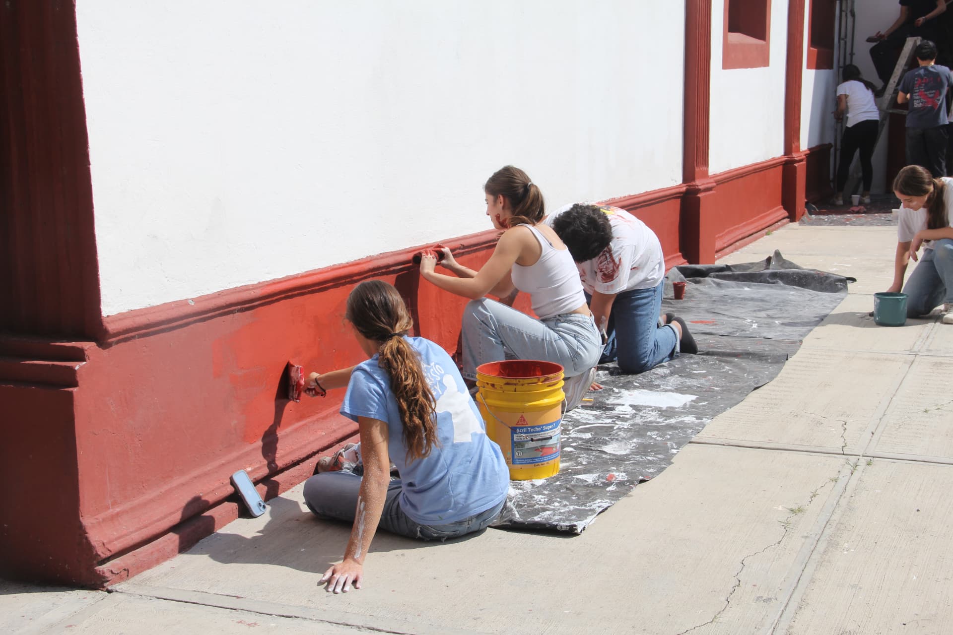Jóvenes de HORIZONS pintando una fachada durante una misión